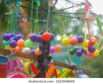 malang, Indonesia -5 february 2023 : the view of a lato-lato toy seller with various colors hanging in a hanging position in the malang city square. lato - lato game
