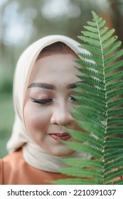 Malang, Indonesia - August 7, 2022 : A Woman Posing With Fern Leaves On The Sidelines Of A Pre-wedding Photo Shoot With A Casual Concept