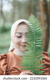 Malang, Indonesia - August 7, 2022 : A Woman Posing With Fern Leaves On The Sidelines Of A Pre-wedding Photo Shoot With A Casual Concept