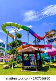 MALANG, INDONESIA - DECEMBER 27 2019: Colorful Slides At Hawai Waterpark Malang With Clear Blue Skies And Green Grass