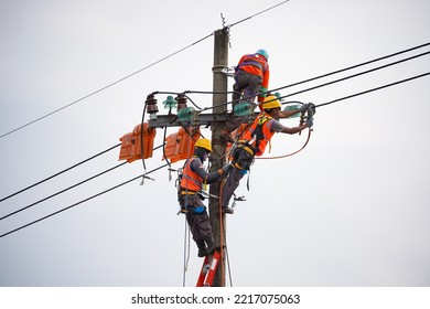 Malang, Indonesia - Oct 4 2022 : Electrical Workers Of Indonesia Electrical Company (PLN) Repair The Cable Which Located 40 Meters Above Ground