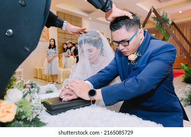 MALANG, INDONESIA - October 11, 2020 : Groom And Bride Is Being Blessed By The Priest In Holy Matrimony