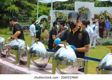 Malang, Indonesia - October 16th,2021: The Waiter Is Serving The Wedding Guests Who Want To Take A Food