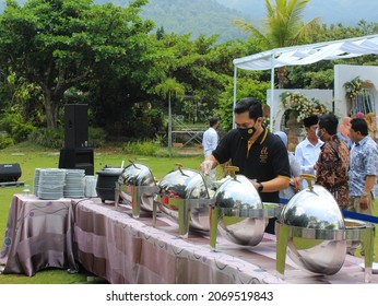 Malang, Indonesia - October 16th,2021: The Waiter Is Serving The Wedding Guests Who Want To Take A Food