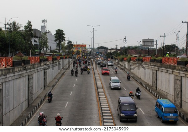 Malang,\
Indonesia - September 28th, 2021: Busy traffic atmosphere in the\
afternoon at the Karanglo underpass, Malang\
City