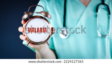 Malaria disease. Doctor shows alarm clock with medical text. Background blue.