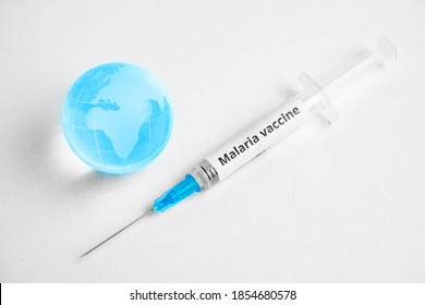 Malaria Vaccine Concept In Syringe With World Map On Globe.