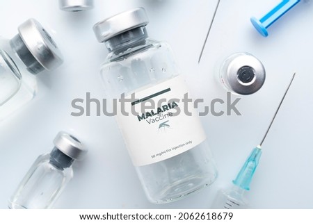 Malaria vaccine concept: vials and syringes on a white plane