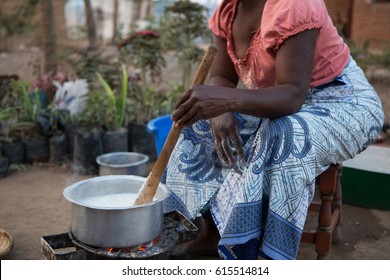 A Malawian woman prepares a traditional dish, a maize paste and the staple food.