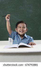 Malay Boy In The Classroom Raising Arm