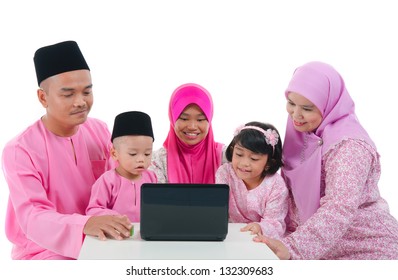 Malay Family With Traditional Maalysian Traditional Clothes And Learning Computer