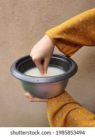 Malay Girl Hand Dip The Tip Of The Index Finger Straight Down Into The Pot To Measure Water Level To Cook Rice. Rice Cooker Inner Pot. Traditional Method. Brown Wall Background. Malaysia. June 2021