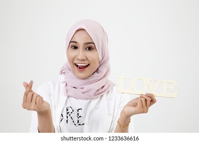 Malay Girl With Hand Forming A Heart Shape, Standing Isolated On White Background.