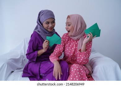 A Malay Girl In Malay Traditional Clothes Shows Her Reaction After Receiving Money Pocket During The Eid Fitri Or Hari Raya Celebration.