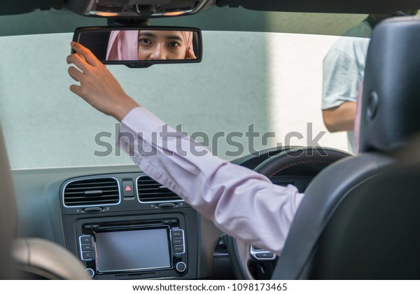 Malay\
Girl wearing hijab Driving Happy smiling in a\
car