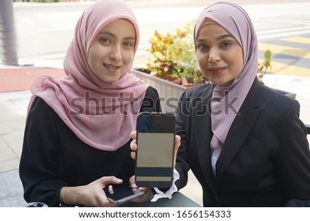 malay muslim business team using QR ewallet payment at cafe

