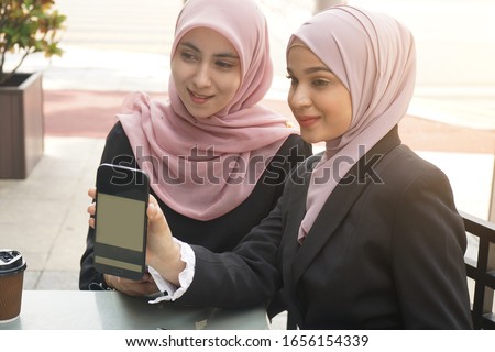malay muslim business team using QR ewallet payment at cafe
