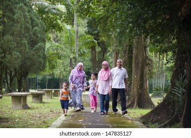 Malay Muslim Family Having Fun Walking In The Park 