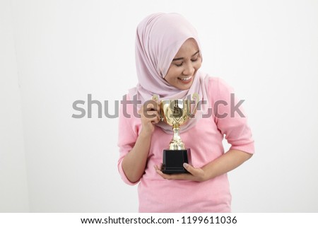 malay woman with tudung holding a golden trophy on the white background