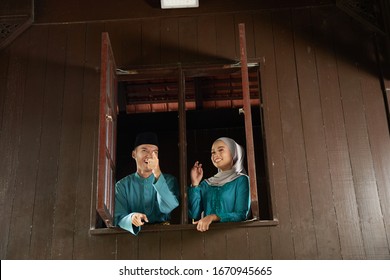 Malay Young Couple At The Wooden Window Of A Traditional Malay House