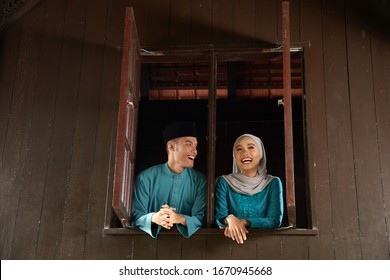 Malay Young Couple At The Wooden Window Of A Traditional Malay House