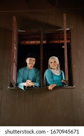 Malay Young Couple At The Wooden Window Of A Traditional Malay House