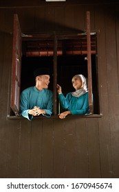 Malay Young Couple At The Wooden Window Of A Traditional Malay House