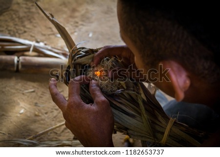 A Malayan aboriginal man makes fire with his hands