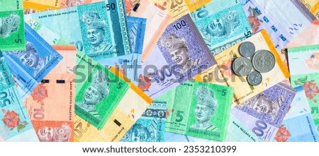 Malaysia currency of Malaysian ringgit banknotes and coins background. Sen coins of fIve, ten, twenty and fifty on paper money of one, five, ten, twenty, fifty and hundred ringgit notes.