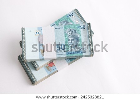 Malaysia Currency Ringgit 50: Stack of Ringgit Malaysia bank note on white background. Selective focus and top view.