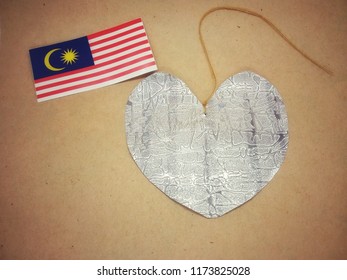 Malaysia Flag And Heart Shape Book Mark On Brown Wallpaper Background.