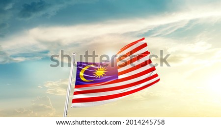 Malaysia national flag waving in beautiful clouds.