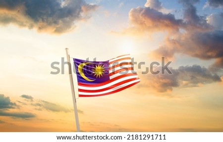 Malaysia national flag waving in beautiful clouds.