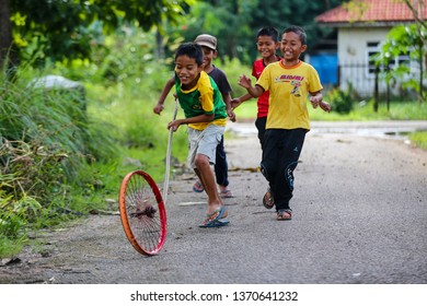 Malaysia,Kedah - Malay Kids Playing With A Bicycle  Rim During Their Free Time,April 2018.