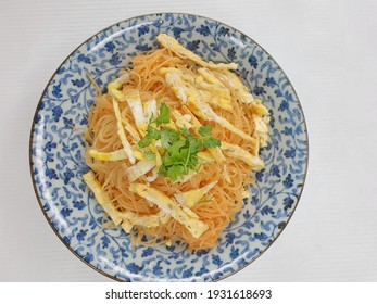 Malaysian Chinese Thin Rice noodles Bee Hoon and fried eggs on white plate, isolated in white background