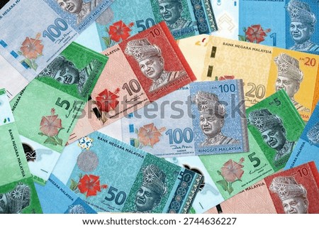 Malaysian ringgit paper banknotes pile on table. Malaysia MYR currency money bills in big amount. Concept of economics, taxation and banking in Malaysia