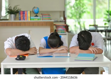 Malaysian secondary students frustrated with school study.Teenagers putting heads down on desk worried about tests and exams.Homeschooling during pandemic in Malaysia.Stressed and depressed.Anxiety.