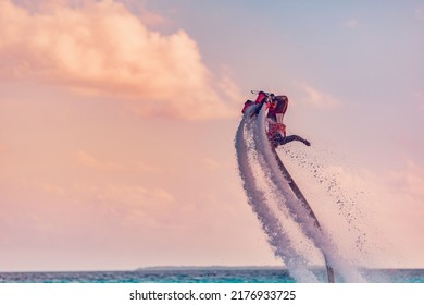 Maldives Island Sunset. Professional Fly Board Rider Doing Back Flip With Tropical Resort Island Background. Sunset Sport And Summer Activity Background, Fun Water Sport