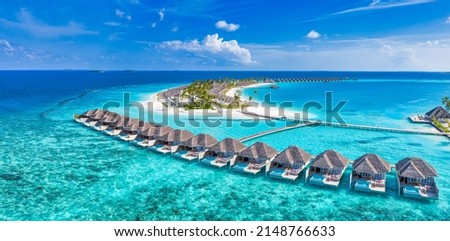 Maldives paradise island. Tropical aerial landscape, seascape with jetty, water bungalows villas with amazing sea lagoon beach. Exotic tourism destination, summer vacation background. Aerial travel
