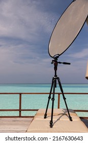 Maldives.Working with a solar reflector for photography on a tripod on the terrace of a luxury room in the Maldives. Photo reflector.