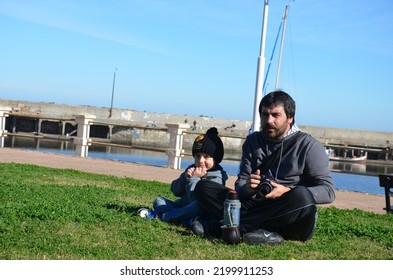 Piriápolis, Maldonado,Uruguai
Jun,15, 2016
Man With Boy Sitting On The Grass At The Dge Of The Beach With Canera In Hand