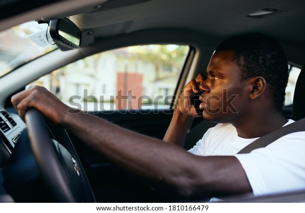 Male African\
appearance driving a car side\
view