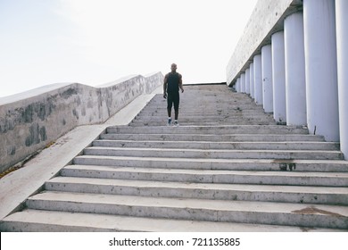 male african athlete running up flight of stairs with speed, training or working out outdoors while jogging up steps - Shutterstock ID 721135885