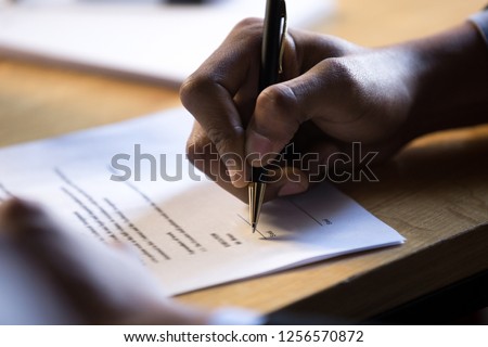 Male african hand signing financial contract concept, black businessman put write signature on legal corporate paper fill document form buy insurance loan, making business agreement, close up view