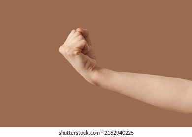 Male Aggressive Fist Gesturing Hand On Brown.