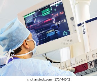 Male anaesthesiologist at monitor in operation room