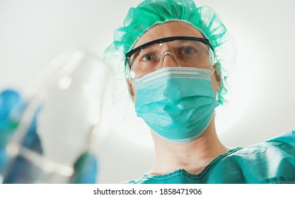 Male Anesthesiologist Giving Gas Mask To Patient.