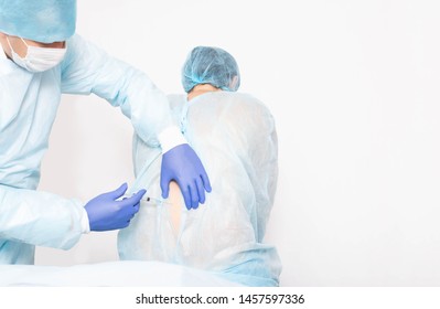 A Male Anesthesiologist Performs A Surgical Procedure That Introduces Epidural Anesthesia Into The Back Of A Girl During Childbirth, Medic, Copy Space