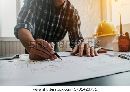 Male architect or engineer working at home drawing the construction project.
