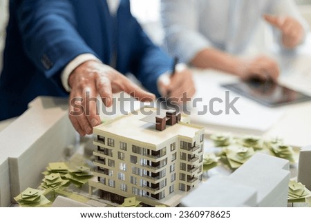 Male architect hands making model house, unrecognizable engineer working in the office.